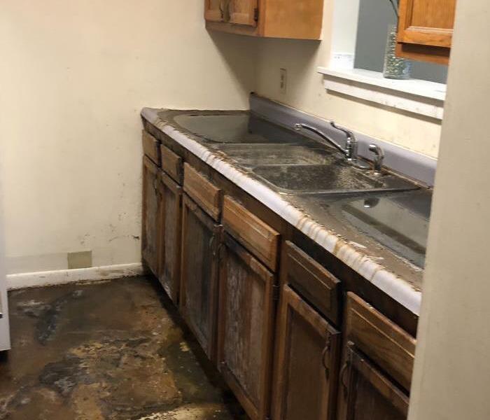 Kitchen after water damage, puddles still sitting on the counter